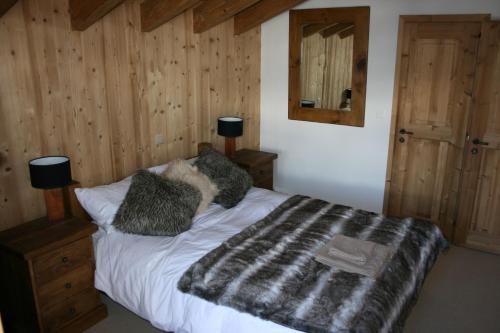 1 dormitorio con 1 cama con manta blanca y negra en Chalet Claire, en Grimentz