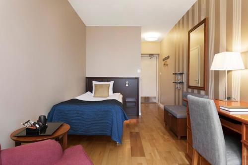 a hotel room with a bed and a desk at ProfilHotels Calmar Stadshotell in Kalmar