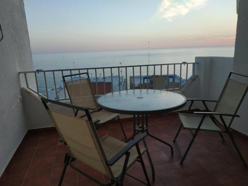a balcony with a table and chairs and the ocean at Kiana Mirador Fuentebravía in El Puerto de Santa María