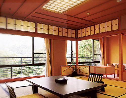 a room with a table and chairs and windows at Ginsuisou Choraku in Kobe