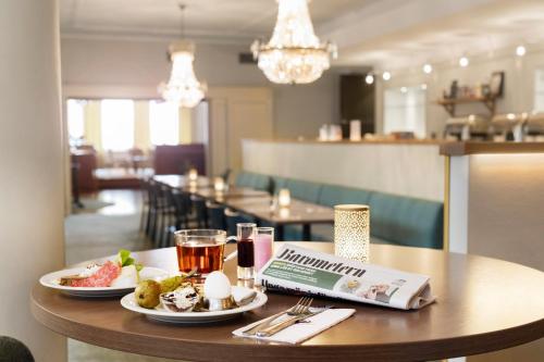 a table with two plates of food and drinks on it at ProfilHotels Calmar Stadshotell in Kalmar