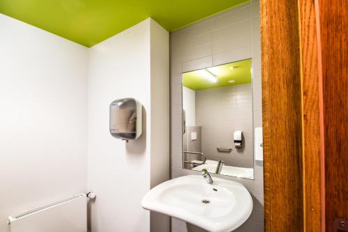 uma casa de banho com um lavatório e um espelho em Liège Youth Hostel em Liège
