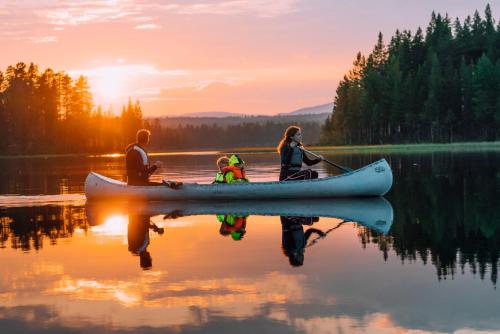a group of three people in a kayak on a lake at Pernilla Wiberg Hotel in Idre