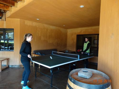 a woman standing in a room with a ping pong table at Kwaggashoek Game Ranch in Geluksburg