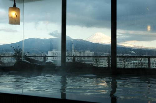 a swimming pool with a view of a snow covered mountain at Dormy Inn Mishima in Mishima