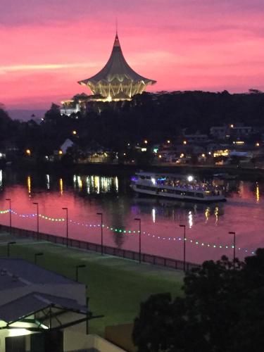 a river with a boat in the water at night at Woodpecker Lodge, Kuching in Kuching