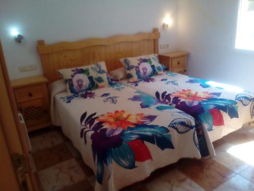 a bedroom with a bed with a floral bedspread at El Molino in Ruidera