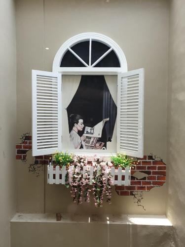 a window with a picture of a man looking out at Danka@Taman Golf Residence in Batam Center