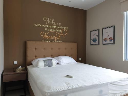 a bedroom with a bed with a welcome sign on the wall at Danka@Taman Golf Residence in Batam Center