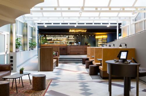 a lobby of a restaurant with tables and chairs at Comfort Hotel Xpress Stockholm Central in Stockholm
