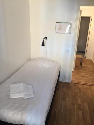 a bedroom with a bed with white sheets and a lamp at Melleruds Golfklubb Bed & Breakfast in Mellerud