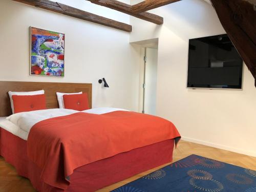 a bedroom with a red bed and a flat screen tv at Best Western Plus Hotel Eyde in Herning
