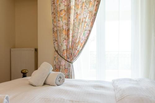 a bed with towels on it with a window at Apartments Nina in Athens