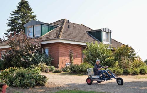 a boy riding a trike in front of a house at Ferienhof Andreas Hansen in Rettin