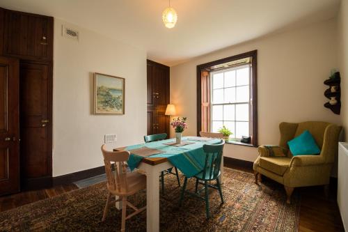 WhiteheadにあるBlackhead Lighkeeper's Houses, Antrimのテーブルと椅子と窓のあるダイニングルーム