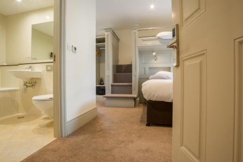 a bathroom with a bedroom with a bed and a toilet at Silken Thomas Accommodation in Kildare