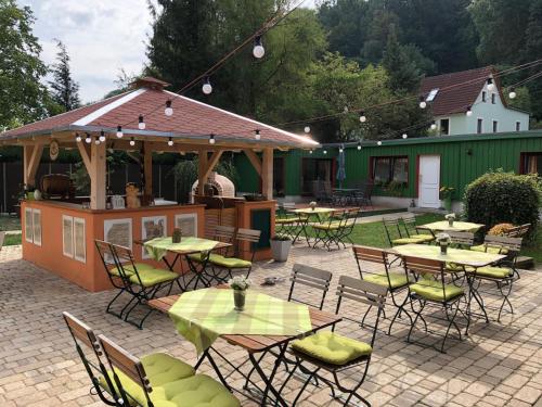 un patio al aire libre con mesas y sillas y un bar en Ferienwohnung Schwemmer, en Pirna