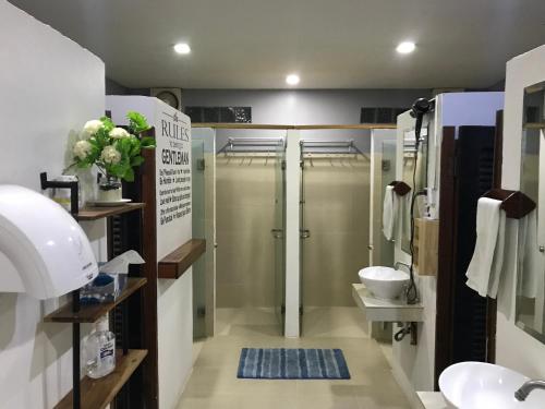 a bathroom with two shower stalls and a sink at Onederz Sihanoukville in Sihanoukville
