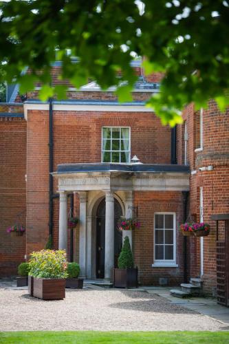a red brick building with a doorway with flowers at Royal Berkshire in Ascot