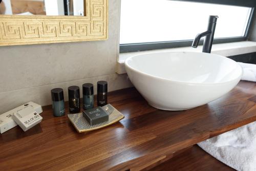 a bathroom with a white sink on a wooden table at The Roof - By Sea Land Suites in Tel Aviv