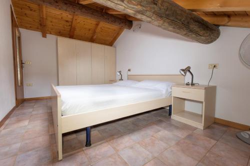 a bedroom with a white bed and a wooden ceiling at Appartamenti Raineri in Domaso