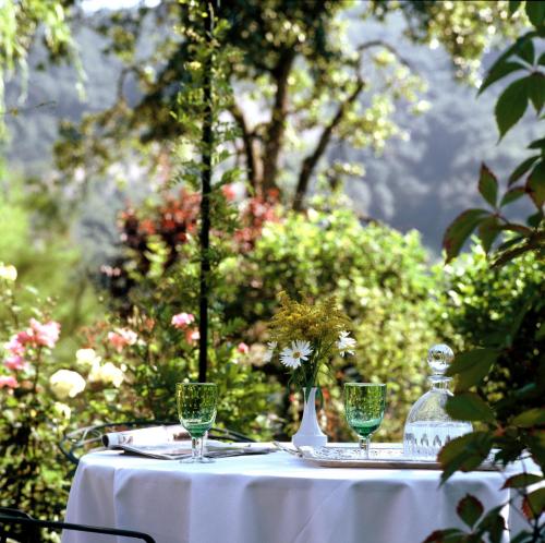 a table with a white table cloth and glasses on it at Hôtel Restaurant Taillard in Goumois