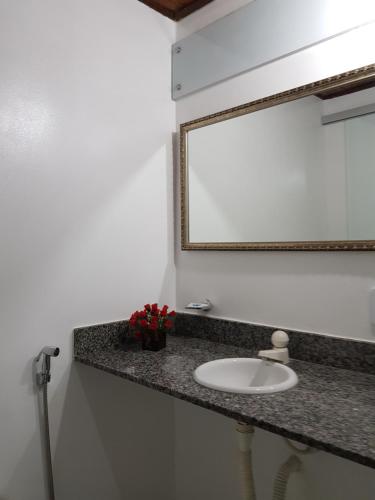 a bathroom with a sink and a mirror at Pousada Sitio Paraiso in Itacaré