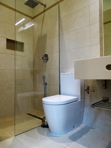 a bathroom with a toilet and a shower at Bowen, Luxury Suites in Lagos