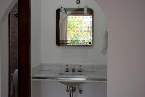 y baño con lavabo y espejo. en Hotel Villagio D'Italia en Vinhedo
