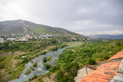 a view of a river with a city and mountains at Golden Fleece in Mtskheta