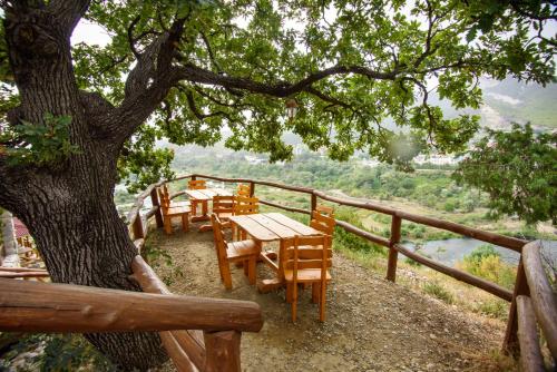 a group of tables and chairs under a tree at Golden Fleece in Mtskheta