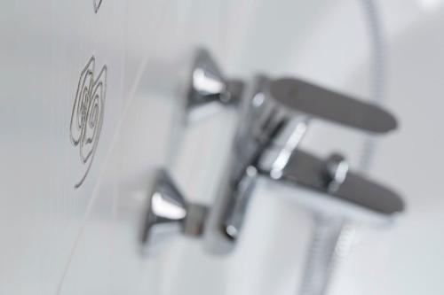a group of faucets on a wall in a bathroom at Lipovka penzion in Hodonín