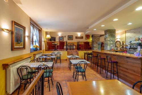 a restaurant with tables and chairs and a bar at Aparthotel les Corts in Llivia