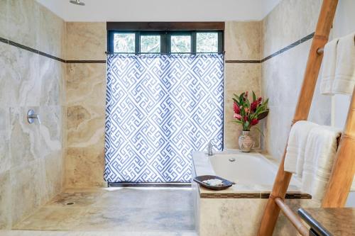 baño con bañera, lavabo y ventana en Makara Toucan Suite / 2nd Floor en Uvita