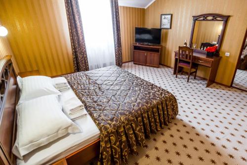 a hotel room with a bed and a desk at Zatyshok in Vinnytsya
