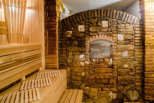 a sauna with two wooden benches in a stone wall at Baltic Beach Hotel & SPA in Jūrmala