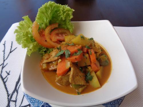 a plate of food with meat and vegetables and lettuce at Ocean Terrace Suite And Spa Luxury in Nusa Penida