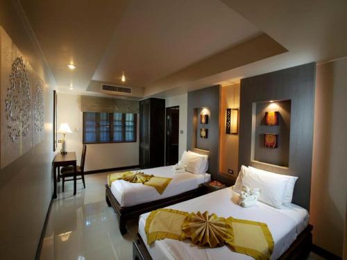 a hotel room with two beds and a table and chair at Smile House - Fisherman Village in Bophut