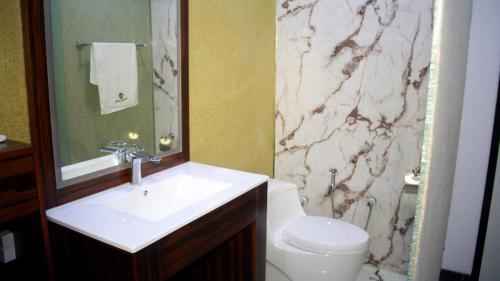 a bathroom with a white sink and a toilet at Melian Hotel in An Najaf