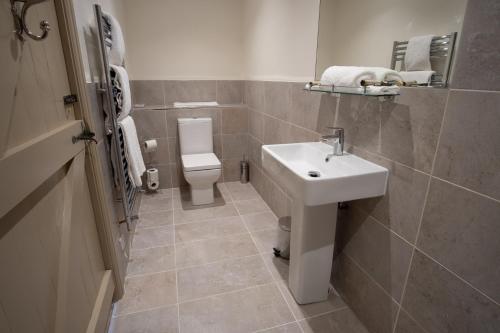 a bathroom with a sink and a toilet at Carlton Towers Stapleton's & Parkgate's in Carlton