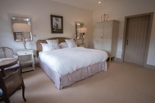 a bedroom with a large white bed and a table at Carlton Towers Stapleton's & Parkgate's in Carlton