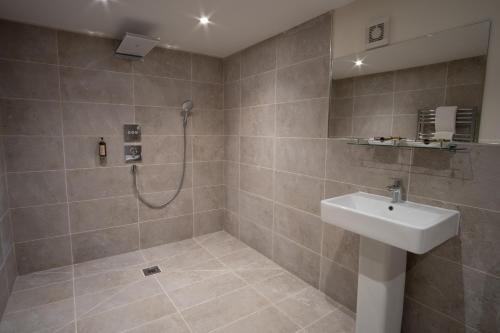 a bathroom with a shower and a white sink at Carlton Towers Stapleton's & Parkgate's in Carlton