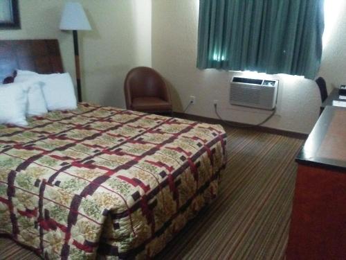 a hotel room with a bed and a air conditioner at Knights Inn and Suites - Grand Forks in Grand Forks