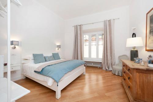 ローマにあるLovatelli Home al Campidoglioの白いウッドフロアのベッドルーム(ベッド1台付)
