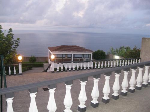 a white fence with the ocean in the background at Casa Santana in Nordeste