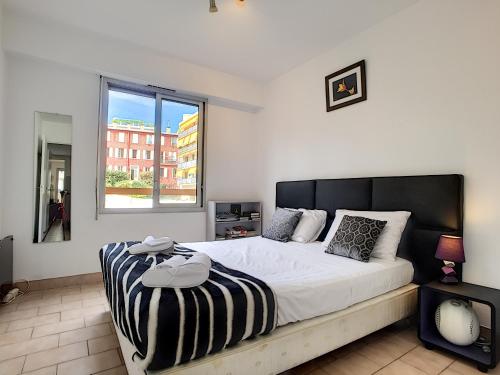 Un dormitorio con una cama grande y una ventana en Nestor&Jeeves - CARDELINE TERRASSE - Very close sea - Spacious en Niza