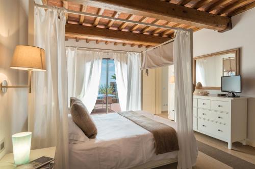 a bedroom with a canopy bed with a view of the ocean at Le Panteraie in Montecatini Terme