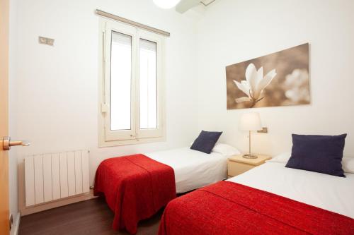 a bedroom with two beds and a window at Rent Top Apartments near Plaza de Catalunya in Barcelona