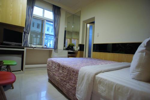 a hotel room with a bed and a window at Xi Xin Guan Hot Spring Resort in Baihe