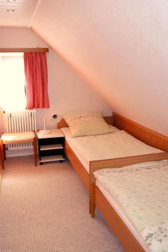 a small bedroom with two beds and a window at Gästehaus Wetzel in Braunlage